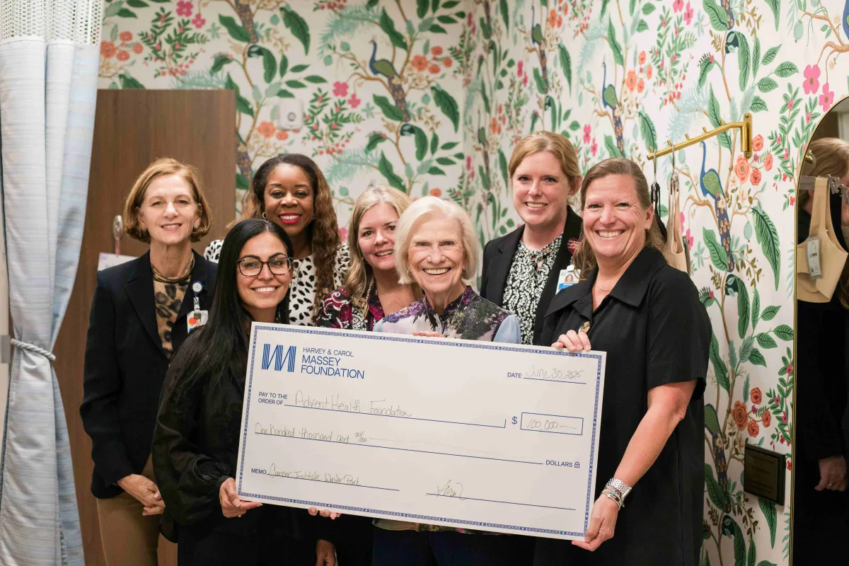 Andrea, Carol Massey and staff of the Winter Park Cancer Institute hold a large check.