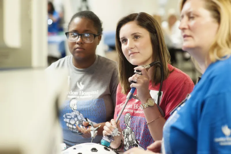 A group of students learning about robotic surgery