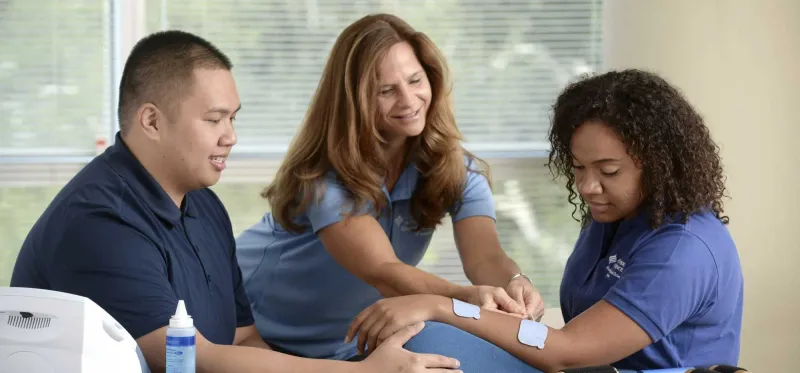 Three nurses going through a bandage training session