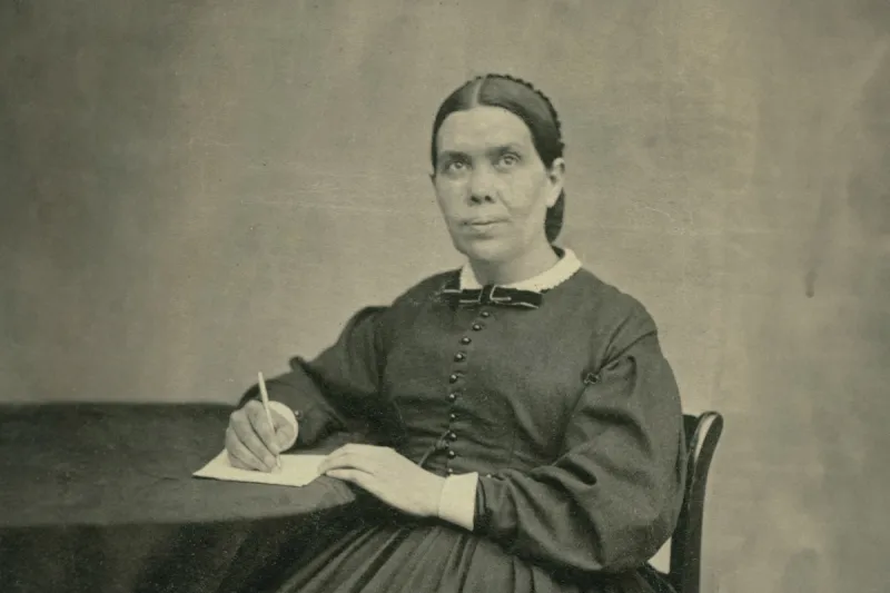 Ellen White writing at a table.