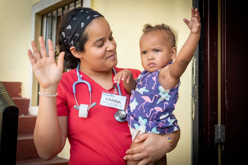 Doctor holding child on a mission trip.
