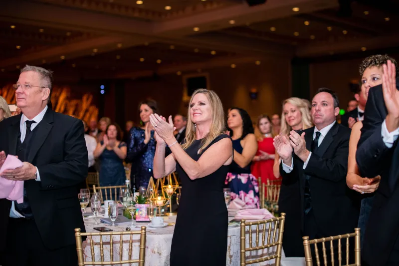 A group of people clapping at a gala night.