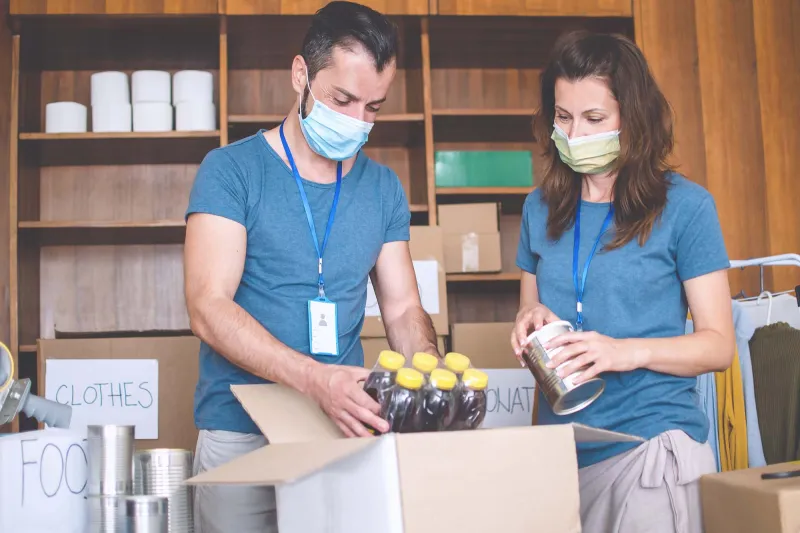 Two food drive volunteers wearing face masks.