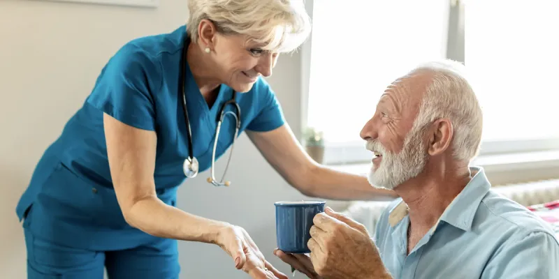 Female nurse talking with a male hospice patient.