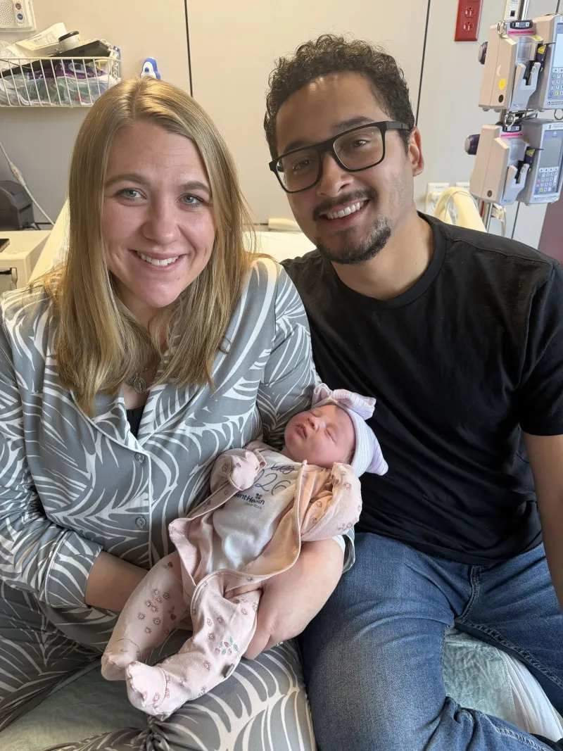 Baby Eliza with her mother and father in a hospital room.