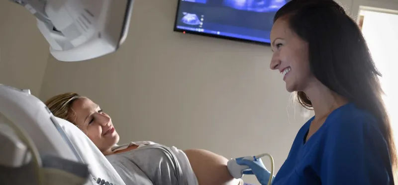 A nurse using an ultrasound on a pregnant mother