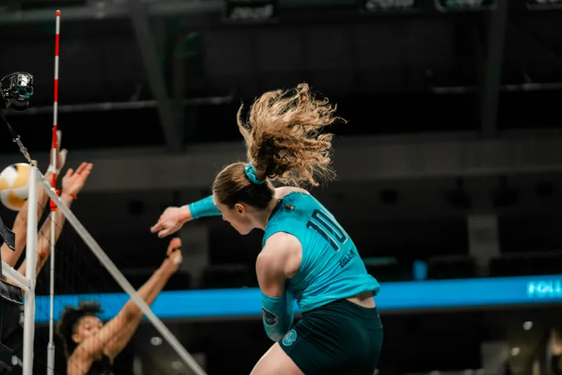 Orlando Valkyries player hits a ball over the net